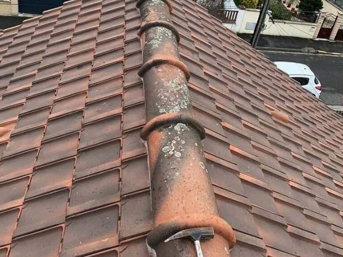 Arêtier dont les faîtières sont descellées et couvertes de mousse